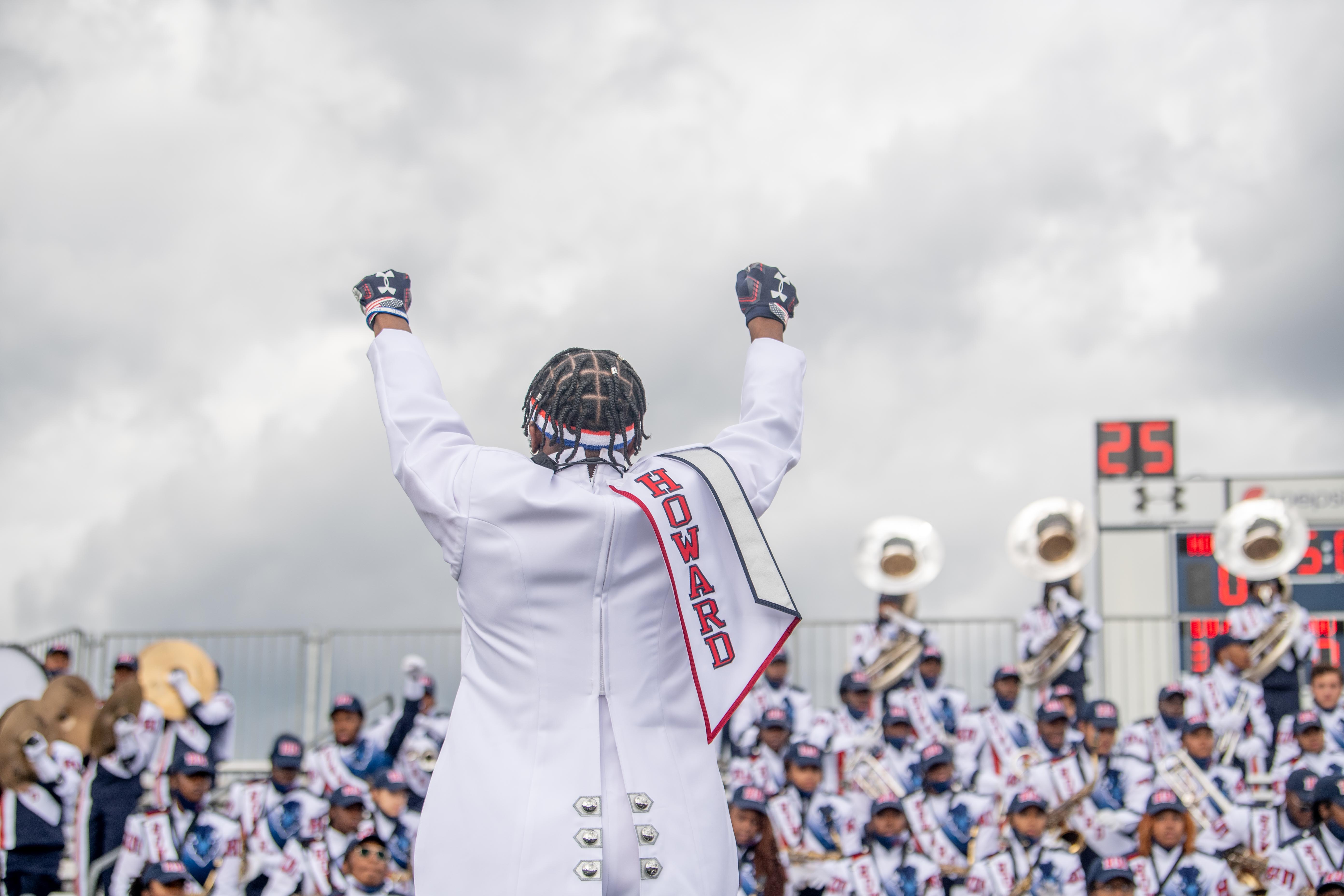 HU Marching Band lead with hands raised