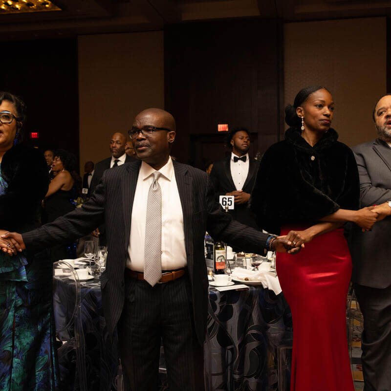 Charter Day Dinner guests holding hands