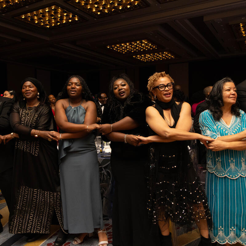 Charter Day Dinner guests holding hands