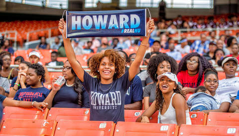 HU alum holding up Howard fan sign in stadium
