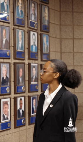 Student looking at previous students on wall